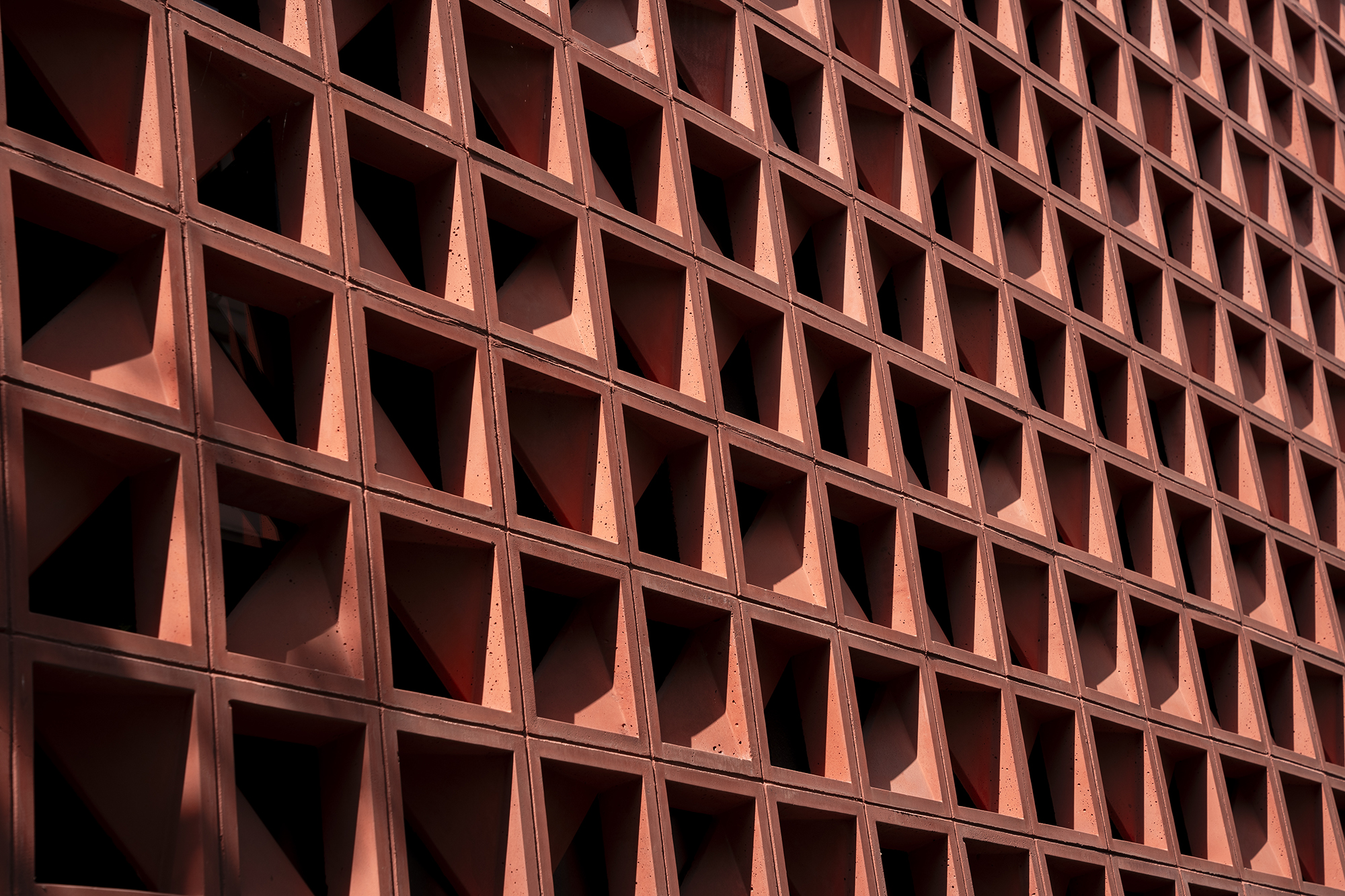 Détail des modules en béton coloré disposés en moucharabieh sur la façade de la Maison COB à Toulouse, projet d'Anaïs Magnabal architecte
